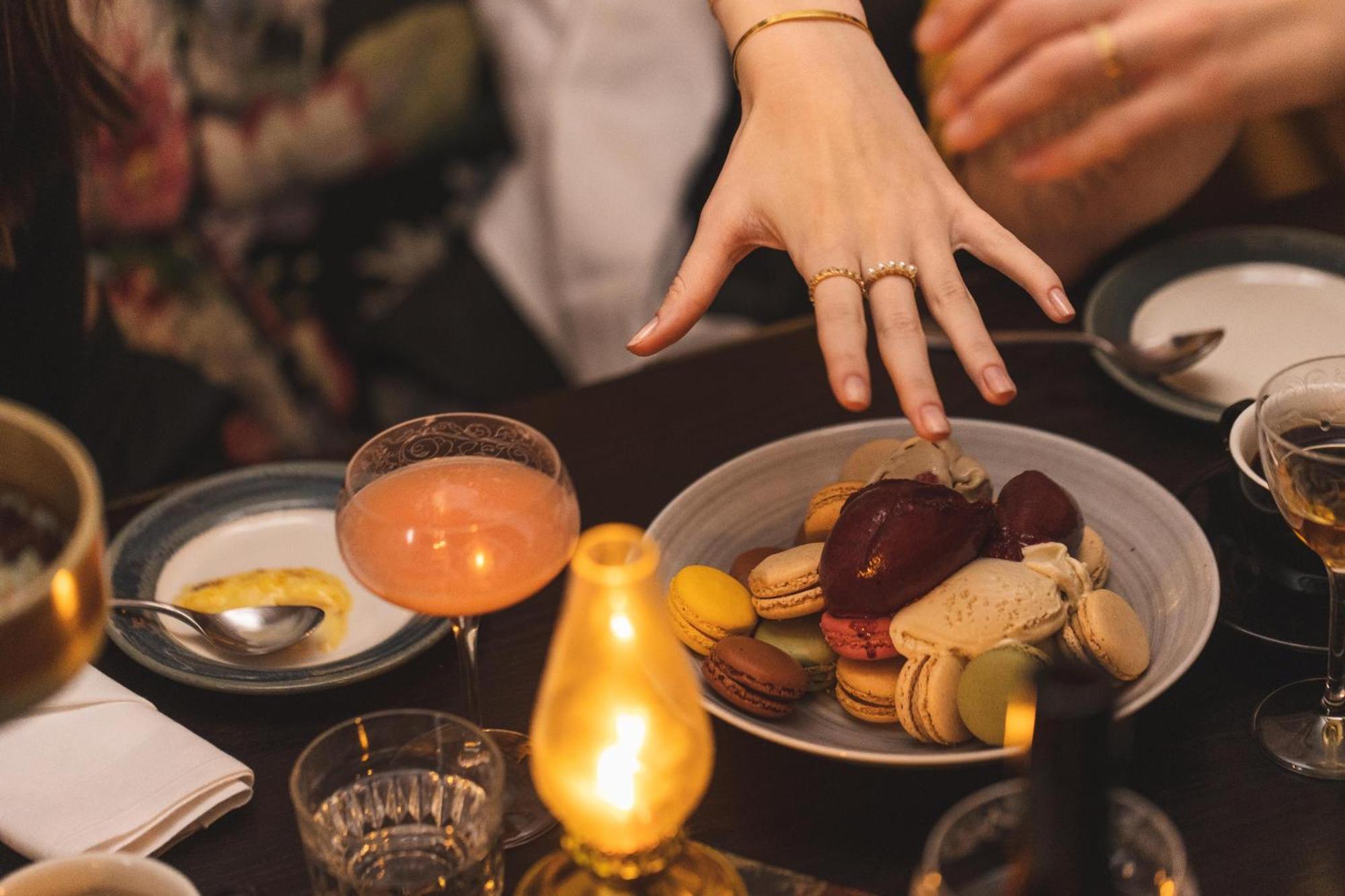 Hotel Pigalle Гётеборг Экстерьер фото A woman's hand reaches for a plate of macarons